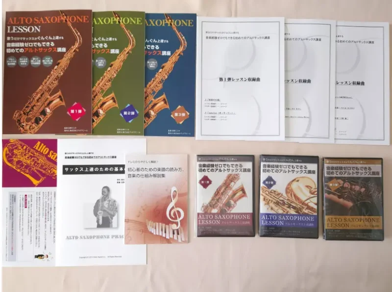 初心者向けアルトサックス講座の教材一式の写真 ・テキスト教本　各弾1冊（計3冊） ・レッスン用楽譜　各弾1冊（計3冊） ・レッスンDVD　第1,2弾 各2枚、第3弾 1枚（計5枚） ・サックス上達のための基本の練習 ・楽譜の読み方、音楽の仕組み解説集 ・同梱内容確認用紙